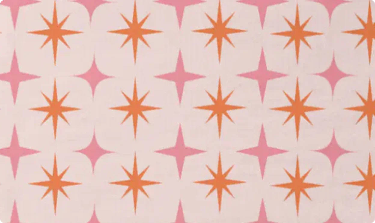 A retro pattern of orange and pink starbursts on cream